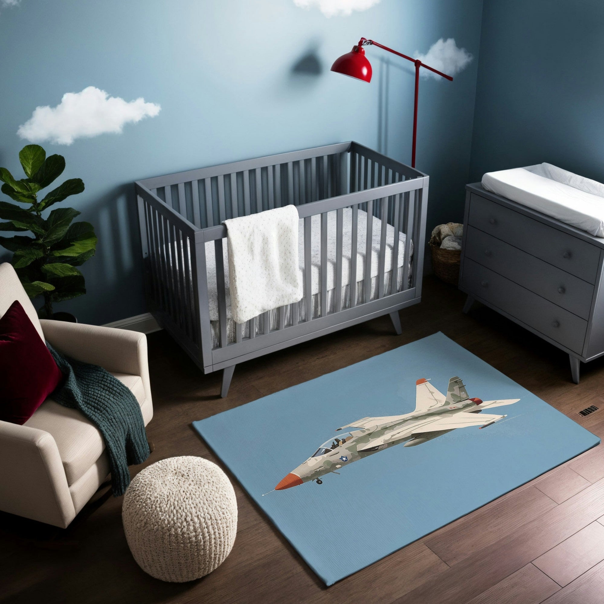 This aviation-themed nursery features a rug with a detailed illustration of a fighter jet in flight against a soft blue backdrop. The room’s design echoes the sky-inspired motif with blue walls and cloud decals, complemented by modern gray furniture and a bright red lamp for a bold accent. The space exudes a playful yet sophisticated vibe, perfect for a budding aviator.