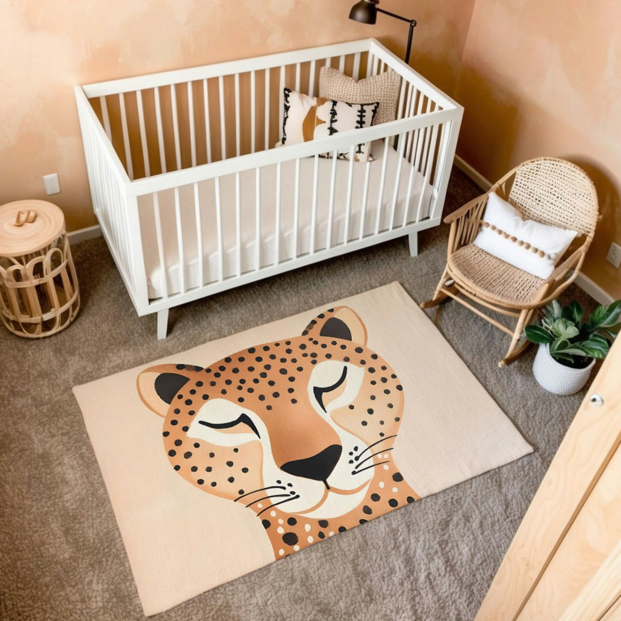 A safari-themed nursery featuring a white crib with neutral bedding, complemented by a natural rattan rocking chair and side table. The room has a soft peachy wall color and includes a bold area rug with a close-up illustration of a cheetah’s serene face, eyes closed in a calm expression. The decor incorporates earthy tones, textured accents, and greenery, creating a cozy and stylish environment.